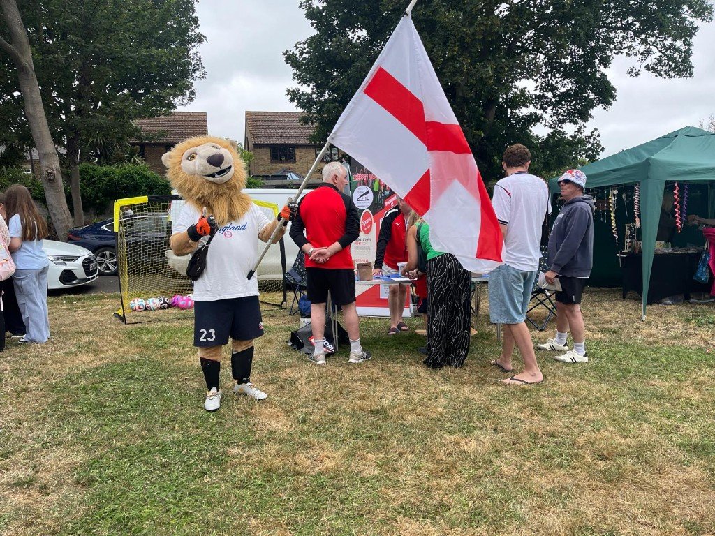 Club lion mascot with the England flag at a community day